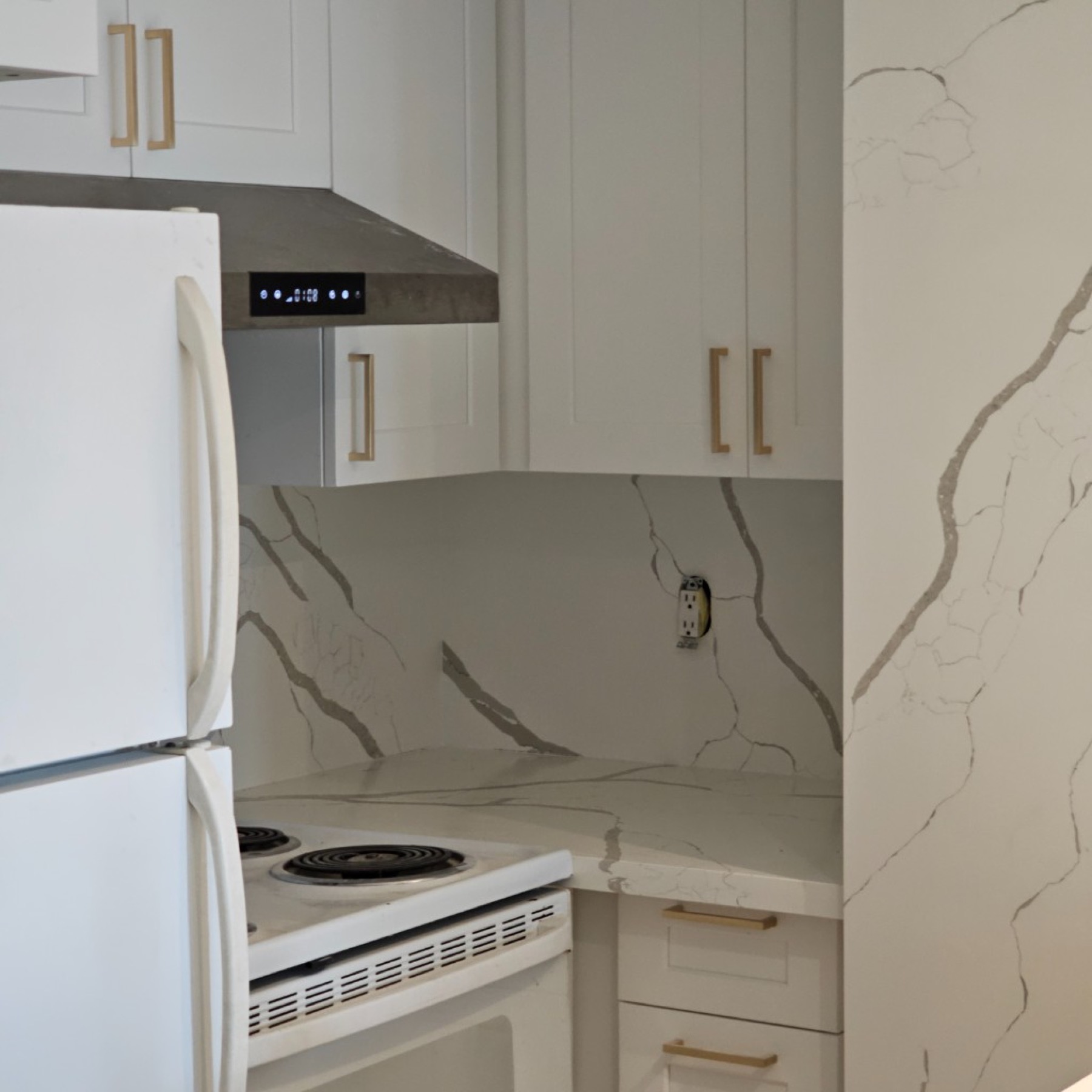 Showroom kitchen with wood hood, glass uppers, and island sink